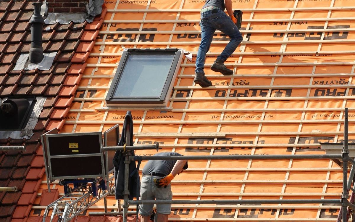 Roofer working at the edge of a roof under renovation